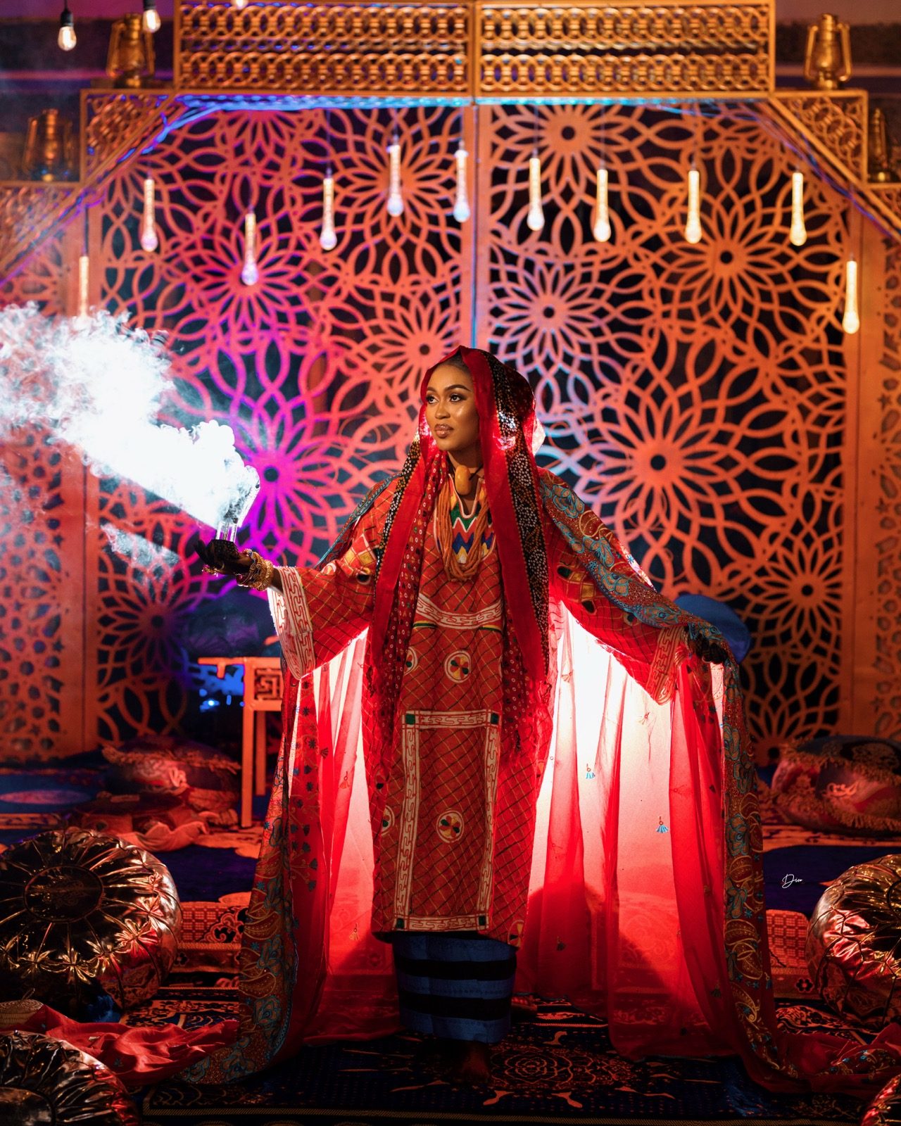 Model in traditional red and teal Kamu ceremonial dress by Haske Spa and Events